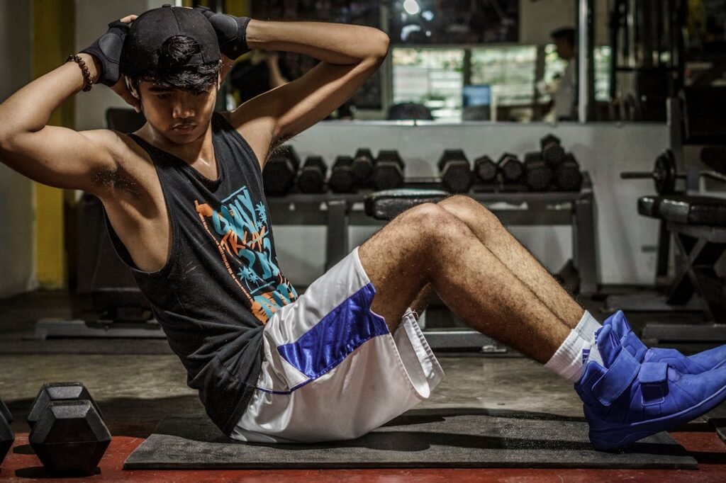 A young man performing sit-ups in a Manila gym, showcasing strength and fitness.
